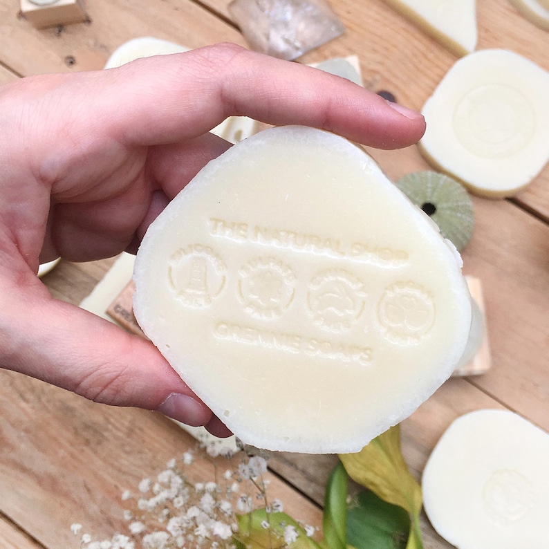 A transparent acrylic soap stamp, part of the related products collection for branding handmade soaps and solid shampoos. The stamp creates a professional, embossed effect directly on the soap, eliminating the need for ink. Ideal for soap makers who prefer a permanent, elegant, and natural-looking logo on their artisanal skincare products.