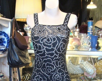 May include: A black sequined evening gown with a fitted bodice and a flowing skirt. The gown is adorned with a delicate floral pattern and is perfect for a special occasion.