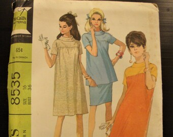 May include: A vintage sewing pattern for a maternity dress in two versions, a dress or a top and skirt. The pattern is from McCall's and is number 8535. The pattern is for size 16 with a bust measurement of 36 inches. The pattern is printed on a green and white background with a picture of three women wearing the dress.