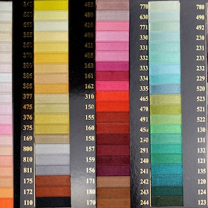 May include: A colour chart showcasing a range of satin ribbons in various shades. The ribbons are arranged vertically, with each colour swatch labelled with a corresponding number. The chart includes shades of pink, yellow, green, blue, and purple.