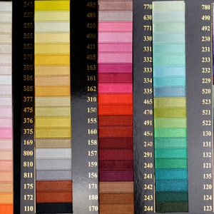 May include: A color chart of ribbon samples with numbers corresponding to each color. The colors range from white to black, with shades of pink, red, orange, yellow, green, blue, purple, and gray.