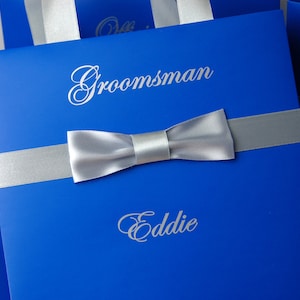 Bolsos elegantes para padrinos de boda con lazo de satén masculino y nombres personalizados Bolso de hombre azul real o negro con pajarita Regalos y recuerdos de fiesta personalizados