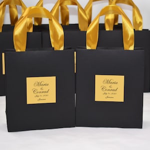 Elegante welkomsttas voor bruiloften met handvatten van satijnen lint en op maat gemaakte tag, gepersonaliseerde zwarte en gouden geschenkzakjes voor huwelijksbedankjes voor gasten