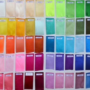 Puede incluir: Una carta de colores de muestras de tela, cada una etiquetada con un n&uacute;mero. Las muestras est&aacute;n dispuestas en filas y columnas, y los colores van del blanco al negro.
