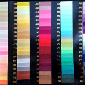 May include: A color chart of ribbon samples with numbers corresponding to each color. The colors range from light beige to dark blue.
