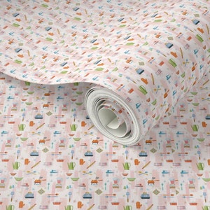 May include: A roll of wallpaper featuring a repeating pattern of kitchen utensils and appliances. The design includes blenders, kettles, spatulas, and bowls in various colors, set against a pink and white background.