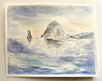 May include: A watercolor painting of a rocky island with a smaller rock formation in the foreground. The water is a light blue with hints of green and white, reflecting the sky and the island. The sky is a soft blue with hints of yellow and purple.