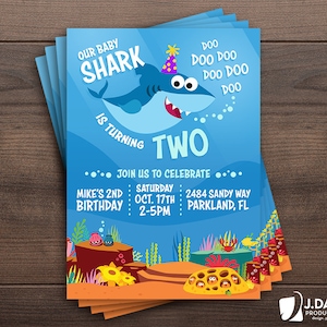 May include: A blue and orange birthday invitation with a cartoon baby shark wearing a party hat. The text reads "Our Baby Shark is Turning Two" and includes details for a party on October 17th.