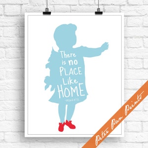 May include: A framed print featuring a light blue silhouette of a child with the quote "There is no place like HOME" from The Wizard of Oz. The child is wearing red shoes. The print is on a white background.