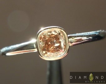Op de afbeelding: Een gouden ring met een kussen geslepen champagne diamant in een bezel setting.