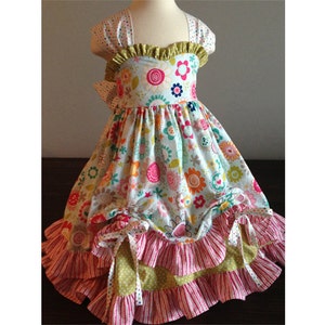May include: A white dress with a floral print and a green, pink, and yellow ruffled skirt.