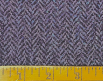 May include: Close-up of a dark purple and black herringbone fabric with a ruler measuring 3 inches.