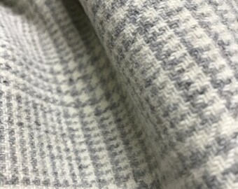 May include: Close-up of a white and gray fabric with a houndstooth pattern.