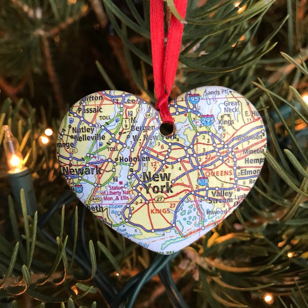 May include: A heart-shaped Christmas ornament made from a map of New York City. The ornament is red and white and features the text "New York" in the center.