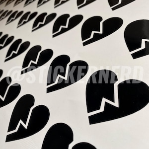 May include: A collection of black heart-shaped stickers with a broken heart design. The stickers are arranged on a white background. The text "@STICKERNERD" is visible in the image.