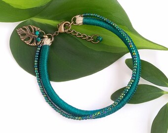 Quetzal green beaded bracelet with Monstera leaf charm . Dark green embroidery floss bracelet . choose your length + 1" chain