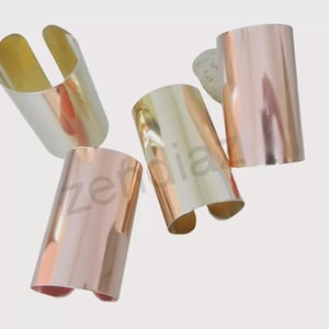 May include: Four metallic cuff bracelets in silver, gold, and rose gold. The bracelets have a smooth, polished finish and a simple, modern design. The cuffs are open at the bottom, allowing them to be easily slipped onto the wrist. A stylish accessory for any outfit.
