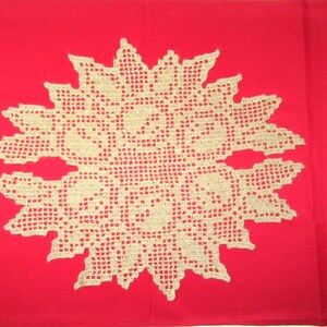 May include: A beige, star-shaped crochet doily featuring an intricate, open-work grid pattern with floral-like motifs. The doily is centered against a solid, vibrant red background, creating a high-contrast visual display of the textile design.