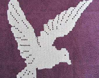 Decoratieve placemat met duifthema. Witte katoenen gehaakte vogel. Decoratief kleedje thema duif. Witte katoenen gehaakte vogel.