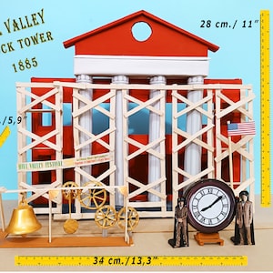 Può includere: Un modello della Torre dell'Orologio di Hill Valley dal film Ritorno al Futuro, in costruzione con impalcature. La torre è rossa con colonne bianche e un quadrante dell'orologio. Il modello è alto 28 cm e largo 34 cm.