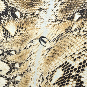 Pode incluir: Um close-up de um tecido com padrão de pele de cobra marrom e preto com a palavra "Just Cavalli" impressa em branco.