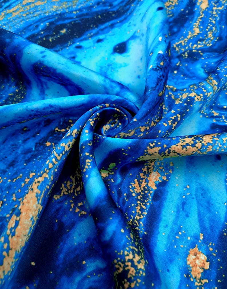 Puede incluir: Tela azul y dorada con un patr&oacute;n de m&aacute;rmol. La tela es suave y sedosa.