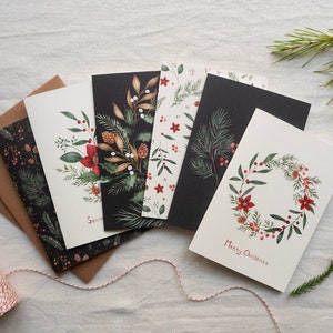 Set of 6 botanical Christmas cards with different branches and flowers on cream white and black backgrounds.