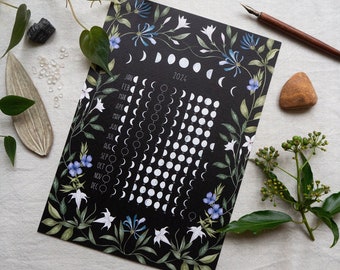 May include: A black and white moon phase calendar for 2024 with a floral design. The calendar shows the phases of the moon for each month of the year. The floral design features white flowers and blue flowers on a black background.