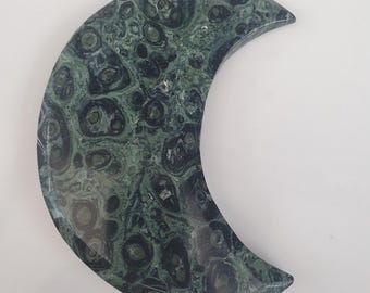 May include: A green and black crescent moon shaped dish made of polished stone. The stone has a swirling pattern of green and black.