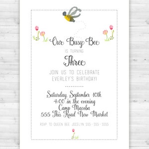 May include: A white invitation card with a watercolor illustration of a bee and flowers. The text reads "Our Busy Bee is Turning Three. Join us to celebrate Everley's Birthday! Saturday, September 10th 4:00 in the evening Camp Macoba 555 This Road New Market RSVP to Queen Bee Jocelyn 555-555-5555"