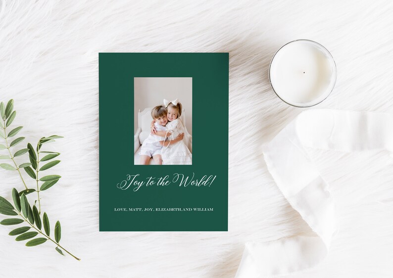 May include: A green Christmas card with a photo of two children hugging. The card reads "Joy to the World!" and "Love, Matt, Joy, Elizabeth, and William".