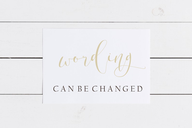 May include: A white card with the words "wording" in elegant gold script above the text "CAN BE CHANGED" in a simple, black sans-serif font. The card is set against a white wooden background.