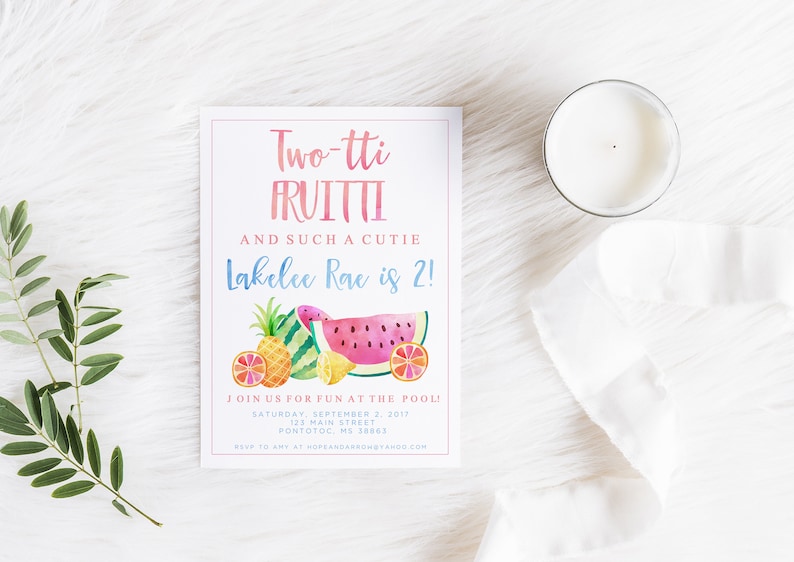 May include: A party invitation with the text "Two-tti FRUITTI" and "Lakelee Rae is 2!" features watercolor illustrations of fruit. A white candle and a sprig of greenery are also in the image.