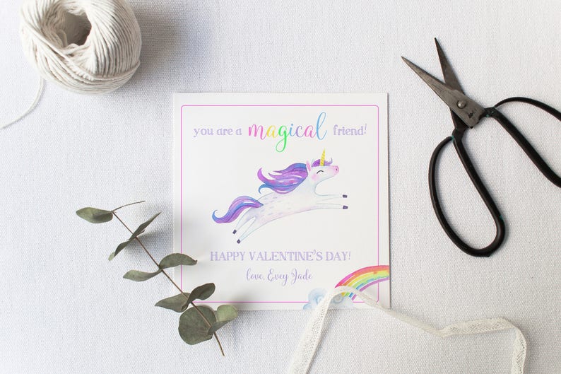 May include: A white card with a purple, pink, and blue unicorn illustration. The card says "You are a magical friend! Happy Valentine's Day! Love, Every Jude" with a rainbow and clouds in the background.