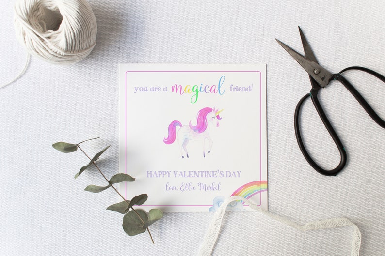 May include: A white card with a pink border and a watercolor illustration of a unicorn with a rainbow. The card says "You are a magical friend! Happy Valentine's Day love, Ellie Merkel"