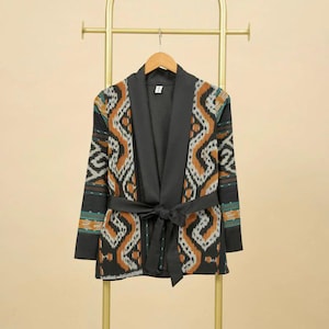 May include: A black and brown patterned kimono-style jacket with a black satin lining and a tie belt.