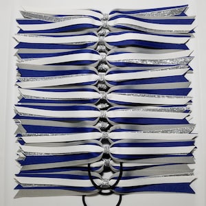 May include: Set of 10 hair ties with blue, white, and silver striped ribbon. Each tie is tied in a bow shape.