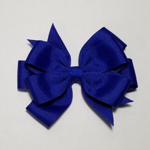May include: A large, royal blue hair bow with a center loop and pointed ends.