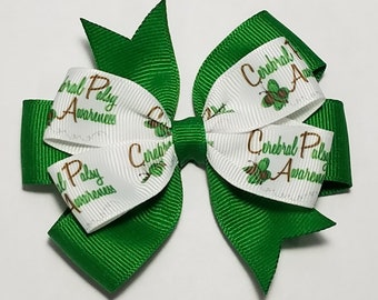 May include: Green and white ribbon hair bow with the text "Cerebral Palsy Awareness" repeated on the ribbon. The bow is tied in a classic style with a green center.