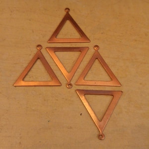 May include: Five copper triangle charms with a hole at the top. The triangles are hollow and have a shiny finish.