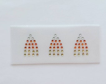 Op de afbeelding: Drie kleine, driehoekige strijkpatches met een verloop van oranje, rode en zilveren strasssteentjes.