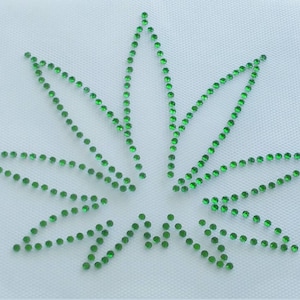 Może przedstawiać: Zielone kryształki ułożone w kształt liścia marihuany na białym tle.