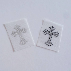 May include: Two iron-on patches featuring a cross design. One patch is black with black rhinestones, and the other is white with clear rhinestones.