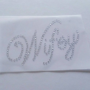 May include: A white fabric patch with the word "Wifey" spelled out in clear rhinestones.