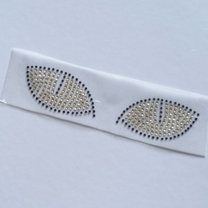 K&ouml;nnte beinhalten: Zwei aufb&uuml;gelbare Patches in Blattform mit goldenen und schwarzen Strasssteinen.