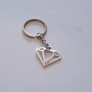 May include: Silver diamond-shaped keychain with a silver key ring.
