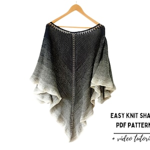 May include: A black and white ombre knit shawl with a crocheted neckline. The shawl is hanging on a wooden hanger. The text "EASY KNIT SHAWL PDF PATTERN + video tutorial" is printed below the shawl.