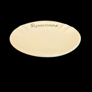 May include: A white ceramic saucer with a scalloped edge and the words "Reno-ware" written in green.