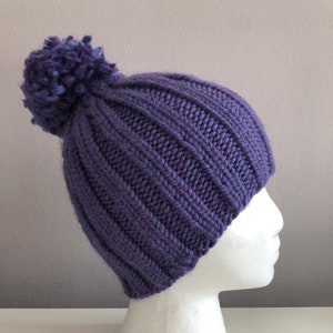 Paarse gebreide muts met pom pom