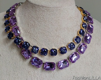 May include: A two-tiered necklace with a graduated ombre effect. The top tier features small, square, dark purple rhinestones. The bottom tier features larger, rectangular, light purple rhinestones. The necklace is made with gold-toned metal.